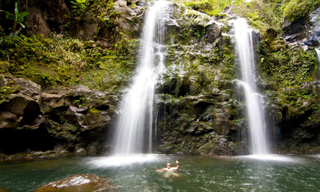 photo of a man near a waterfall, as seen on the road to Hana Maui