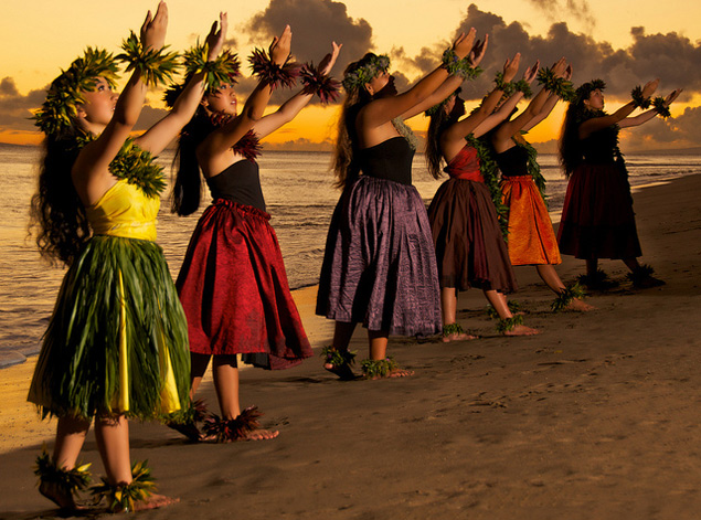 hula dancers performing on the beach in Hawaii at sunset